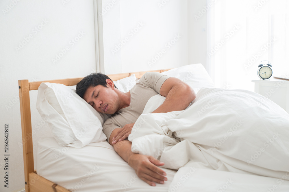 Asian handsome man is sleeping on the comfortable bed in the luxury bedroom. Asian handsome man is sleeping on the comfortable bed in the luxury bedroom.