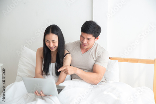 Happy young Asian man and girl is purchasing an online product through the online shopping market. buying, selling, online , pre-order concept.