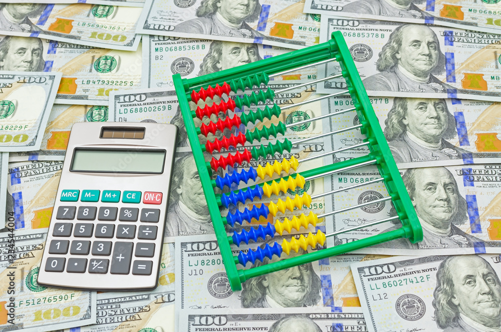Image of abacus and calculator on money background Image of abacus and calculator on money background