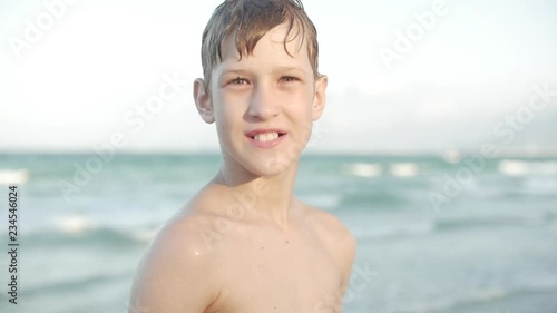 Close up portrait of beautiful young boy teenage tropical beach slow motion. Stock footage. photo