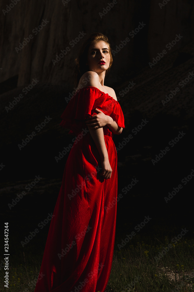 a young charmer in a red dress on a dark background