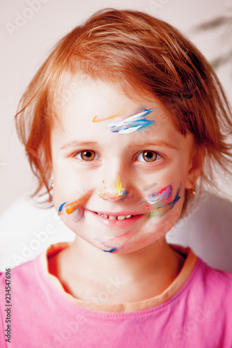 Face painted in colorful paints. Children's meykap. Humorous portrait. (art, childhood, color, creativity concept)