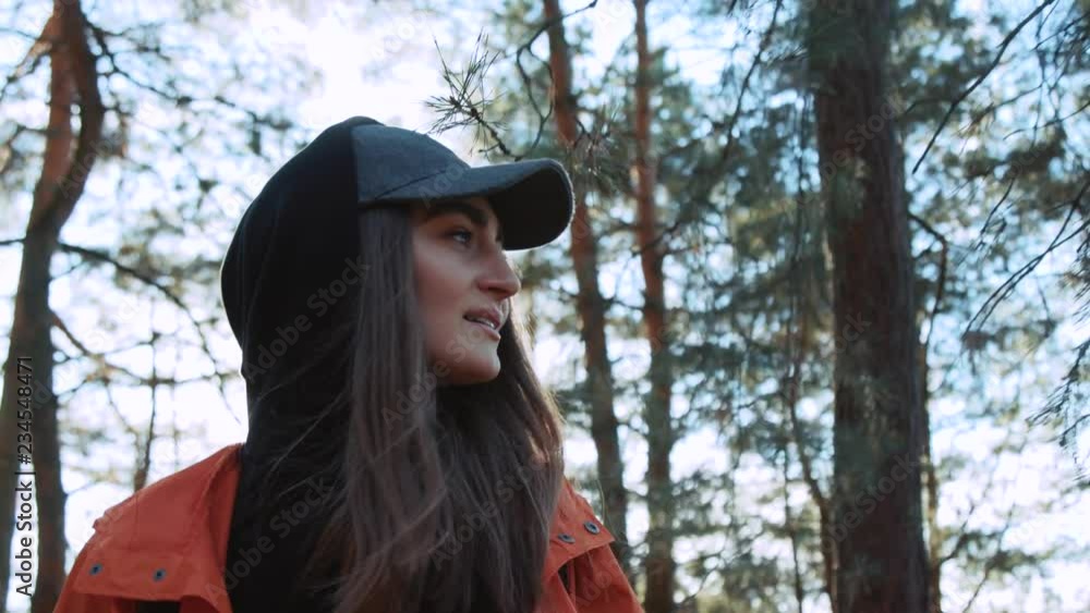 Woman walking in the fall forest on sunny autumn day look around smile adventure nature outdoor sunlight enjoying freedom sky sunshine vacation wind backpack slow motion close up Woman walking in the fall forest on sunny autumn day look around smile adventure nature outdoor sunlight enjoying freedom sky sunshine vacation wind backpack slow motion close up