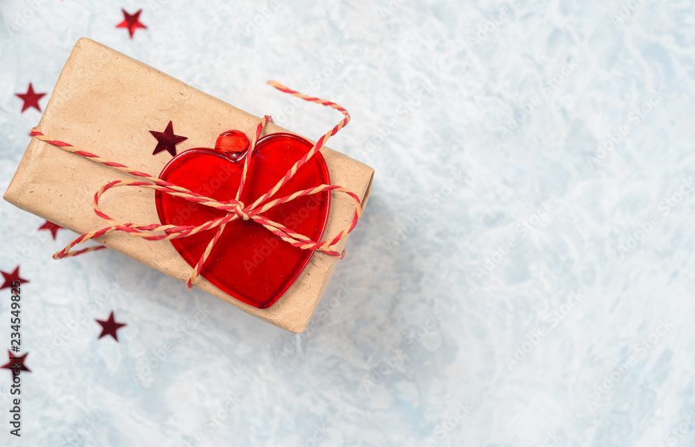 Christmas gift decorated with a decorative heart, surrounded by stars and copy space for your text Christmas gift decorated with a decorative heart, surrounded by stars and copy space for your text