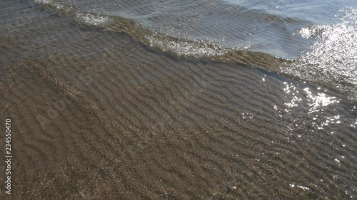 Wallpaper Mural Slow motion sunlit lake water. Shallow sunny water with small waves and rippled sand pattern below.  Torontodigital.ca