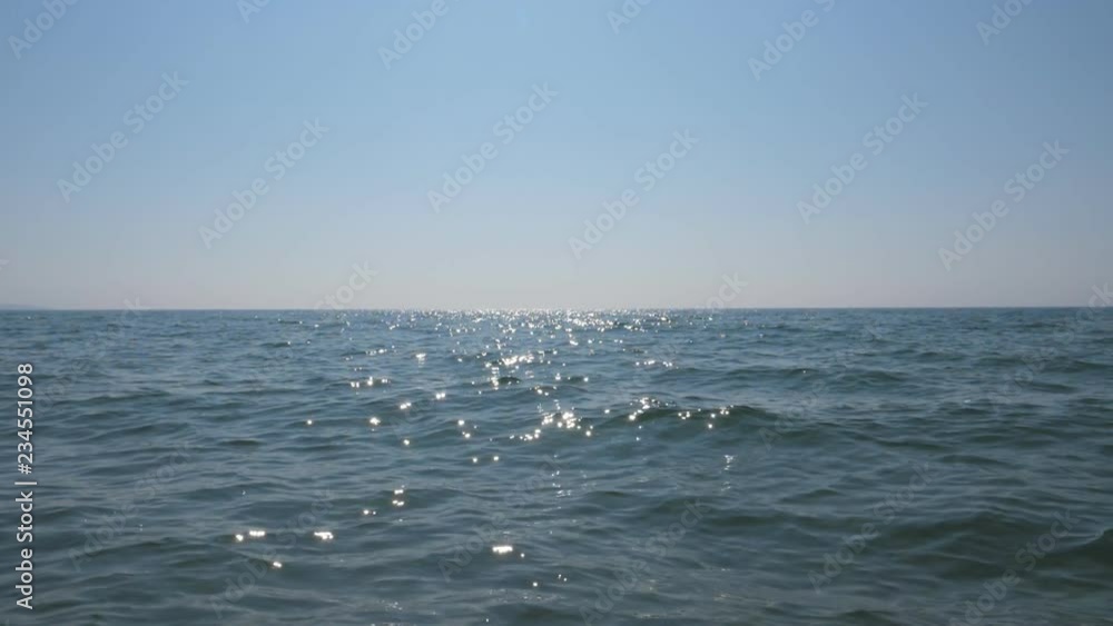 Sparkling lake water with room in blue sky for copy or logo. Slow motion. Prince Edward County, Lake Ontario, Canada. Handheld shot with stabilized camera. Sparkling lake water with room in blue sky for copy or logo. Slow motion. Prince Edward County, Lake Ontario, Canada. Handheld shot with stabilized camera.