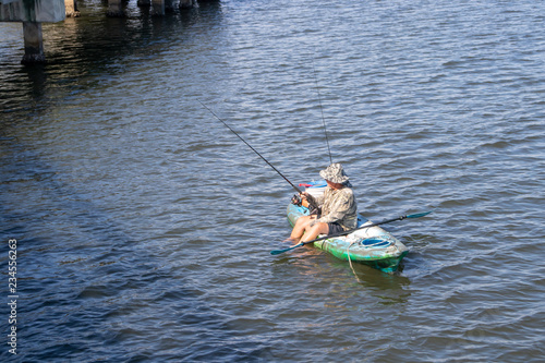 man fishing in a lake in a kayak