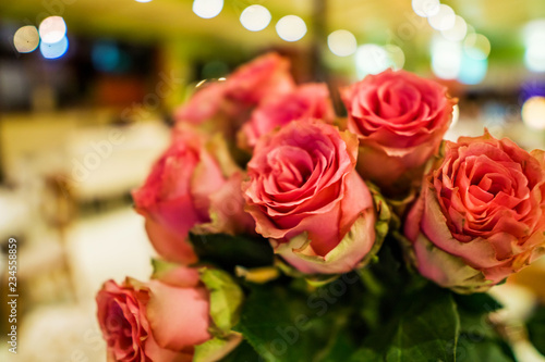 Close up of a beautiful blurry bouquet of roses in soft colors. Bockeh background  restaurant in deaf. Shallow depth of focus. Concept flower for you.