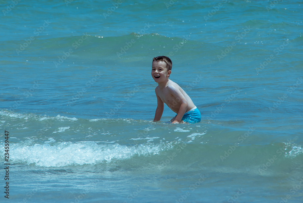 Little white boy bathing in the sea