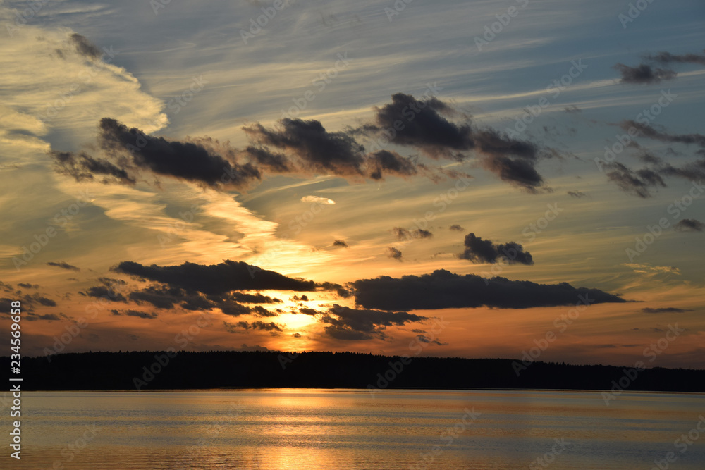 Fototapeta premium evening sunset on the river sea bright light reflection water clouds sky