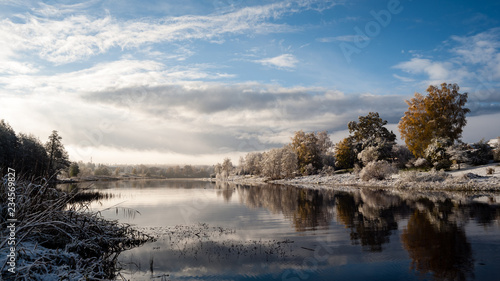 cold and calm morning view by the lake with first snow in winter © Martins Vanags