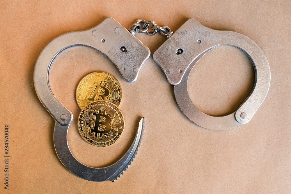 Bitcoins and handcuffs as an abstract symbol of crime that can hide a crypto currency