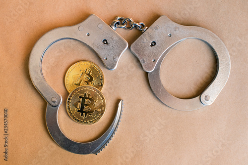 Obraz na płótnie Bitcoins and handcuffs as an abstract symbol of crime that can hide a crypto currency w salonie
