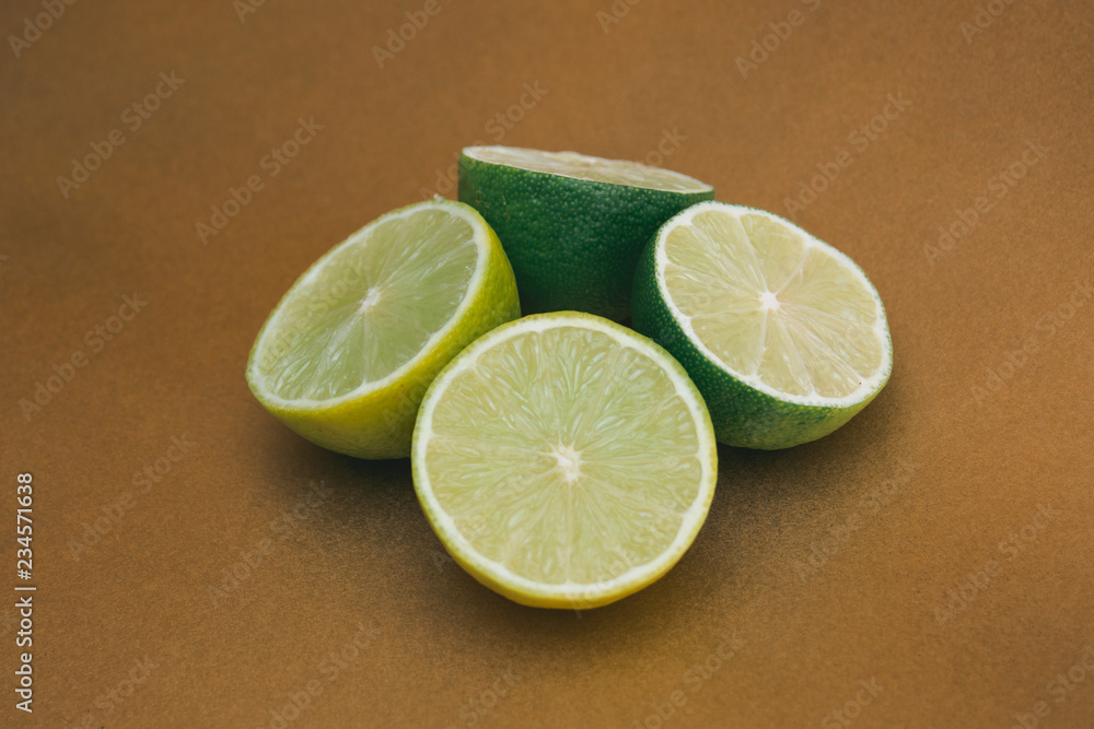 Half of fresh lime, isolated on gold background Half of fresh lime, isolated on gold background