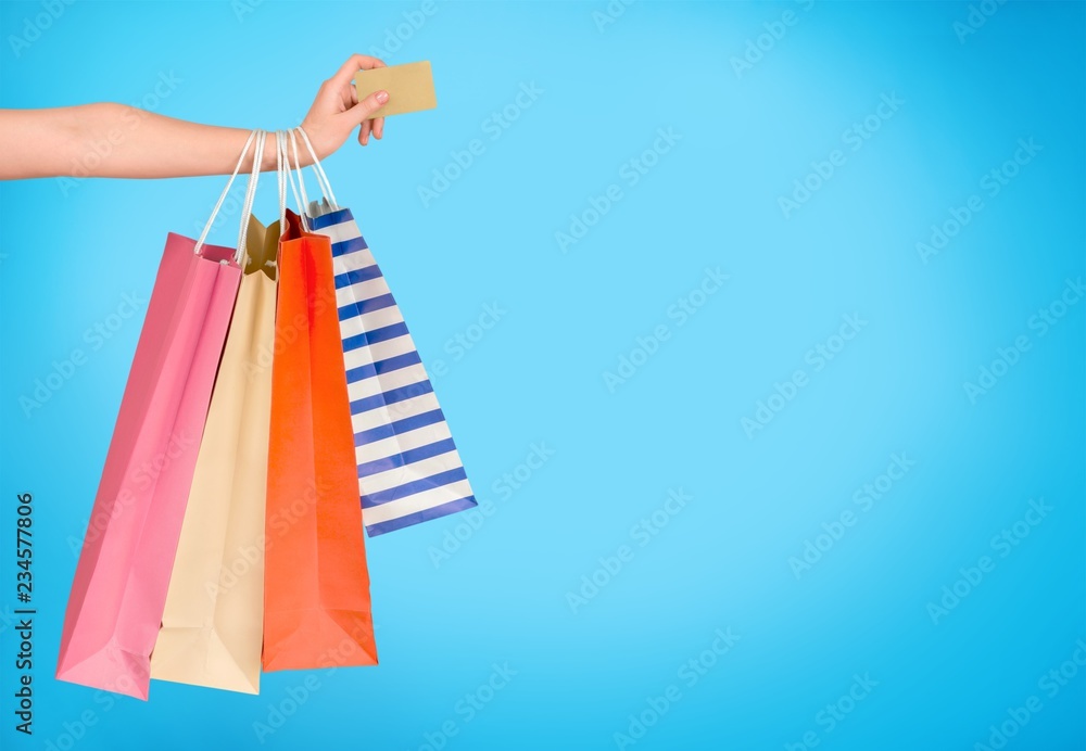 Woman with shopping bags and card on mall background