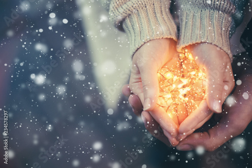 Close view of a couple holding warm Christmas lights