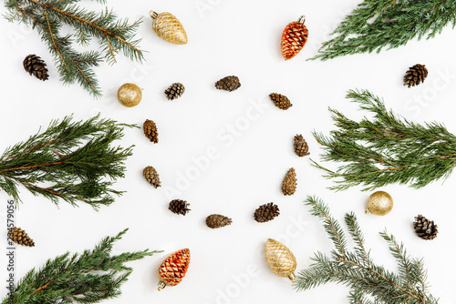 Christmas composition. Christmas toys, coniferous tree branches and a circle of pine cones on white background. Winter, christmas, new year concept. Flat lay, top view, copy space.
