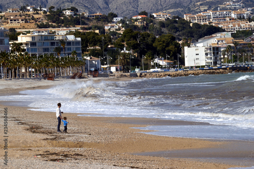 Father and son watching the waves crashing Father and son watching the waves crashing