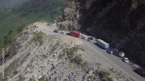 Aerial view of the excavator working on the serpentine road in Vietnam Dalat. Landslide. Vehicle trapped on traffic jam because of the rocks