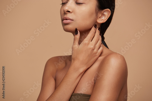 Quadro em tela Portrait of an attractive mixed race girl, stands sideways, demonstrates beautif