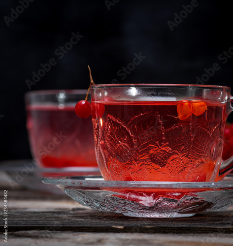 viburnum tea in a transparent cup with a handle and saucer