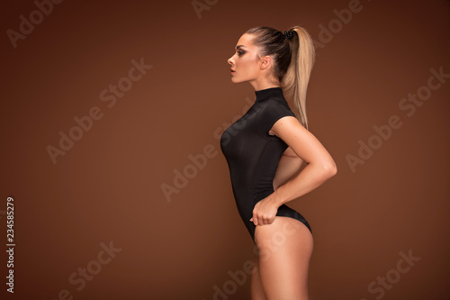 Sensual woman posing on brown background.