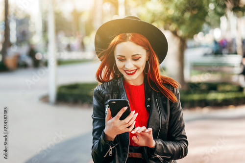 Close up portrait of a young stylish woman holding a smartphone