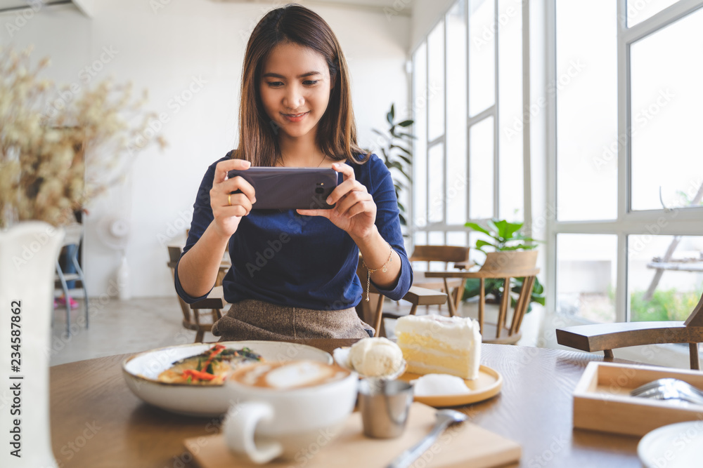 Happy woman take pictures of her food in coffee cafe shop in her chilling holiday Happy woman take pictures of her food in coffee cafe shop in her chilling holiday