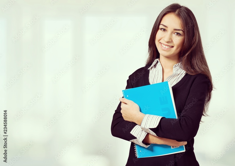 Young female student in blurred library interior Young female student in blurred library interior