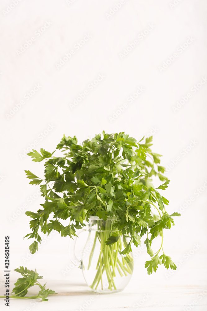 Fresh parsley leaves from the garden in the glass. White background Fresh parsley leaves from the garden in the glass. White background