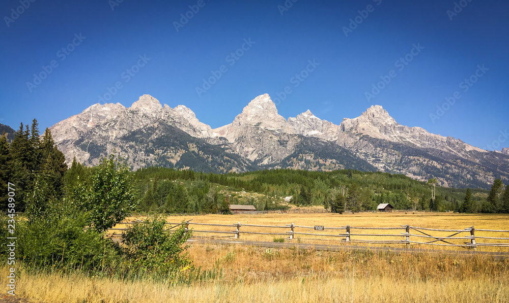 Panorama of Wood Fence and Cabins Beneath Peaks of Grand Teton National Park