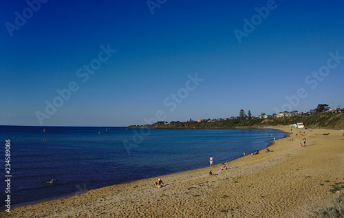 Distant view of people relaxing by the beach