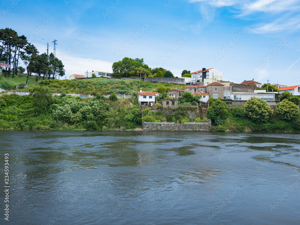View over the Ave River in Vila do Conde, to Azurara village on a sunny summer day with blue skies.
