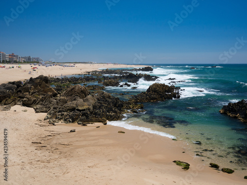 Beautiful sandy   rocky beach in summer  clear blue water and blue cloudless sky in Vila do Conde  Porto  Portugal