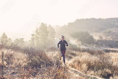 Beautiful Caucasian White Woman Runs on a Trail in the Morning Sunlight © Darren S