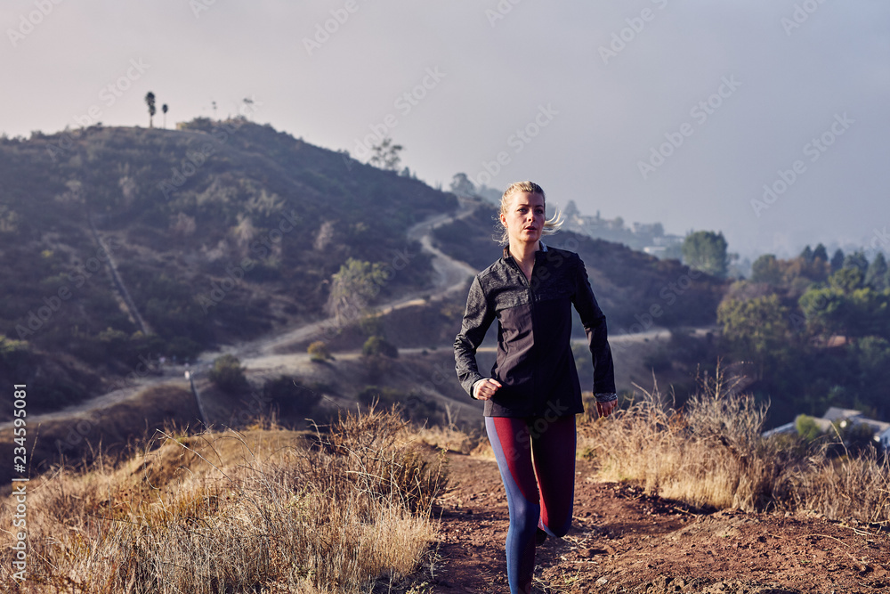 Beautiful Caucasian White Woman Runs on a Trail in the Morning Sunlight Beautiful Caucasian White Woman Runs on a Trail in the Morning Sunlight