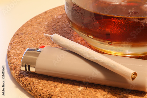 Close-up of a pot cigaret and a drink on the table. Relax time VS Addiction issue photo