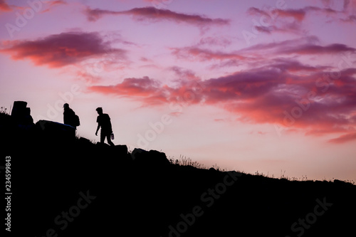 Silhouette of Hikers at Red Sunset © Dallas