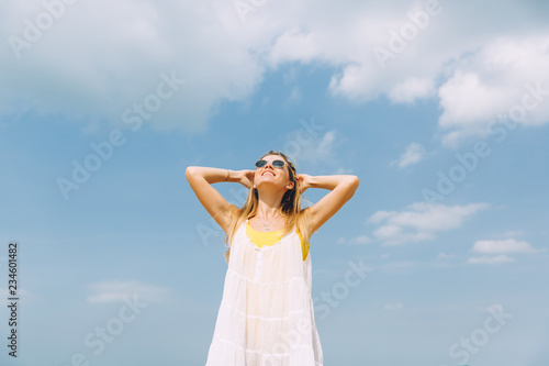 Beautiful woman in sunglasses relaxing at beach on a sunny day ..