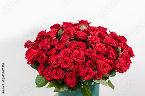 Big luxury bright bouquet on wooden table. One hundred of garden red roses. Color passionately scarlet, Autumn mood. bouquet in a hat box
