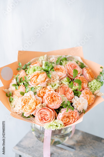 Bouquet of fresh spring flowers on gray wall background. Floral bunch in glass vase. flower shop, florist work