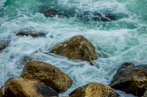 Wavy sea wallpapers crashing into the rocks on the beach, the intensity of sea breezes and storms during the season of nature.