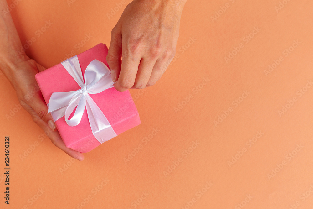 Woman holding gift box on color background Woman holding gift box on color background