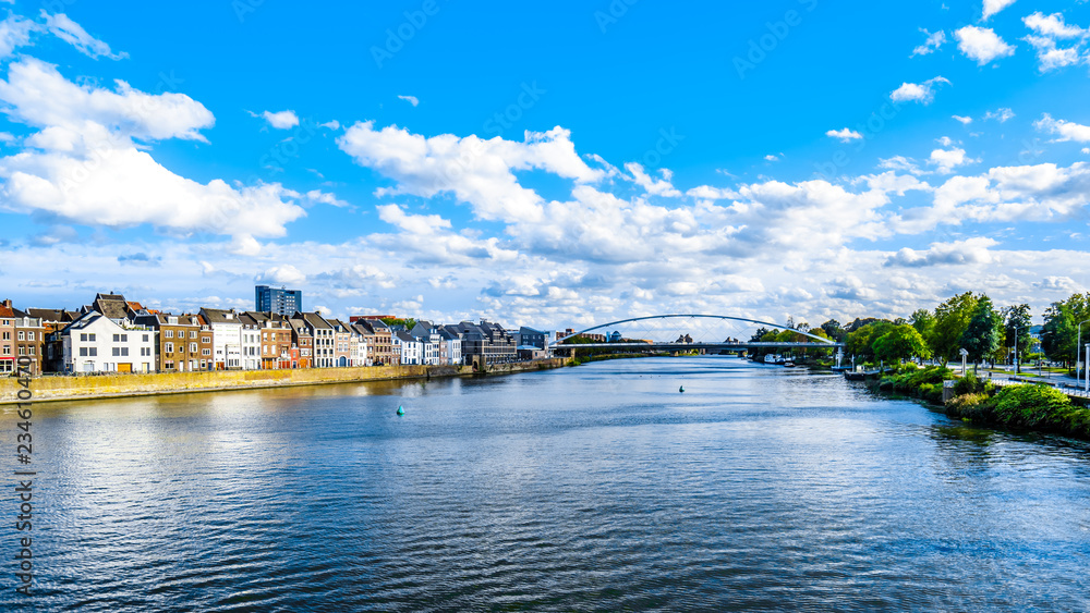Obraz premium The Maas River (Meuse) as it flows through the historic city of Maastricht in the Netherlands. Viewed from the Sint Servaasbrug (St. Servatius Bridge) 