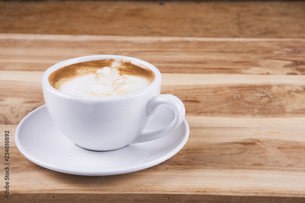 Hot cappuccino or latte art coffee. A cup of coffee on the wooden table with roasted beans. Morning breakfast with coffee. Hearts shape created by pouring steamed milk. Hot cappuccino or latte art coffee. A cup of coffee on the wooden table with roasted beans. Morning breakfast with coffee. Hearts shape created by pouring steamed milk.