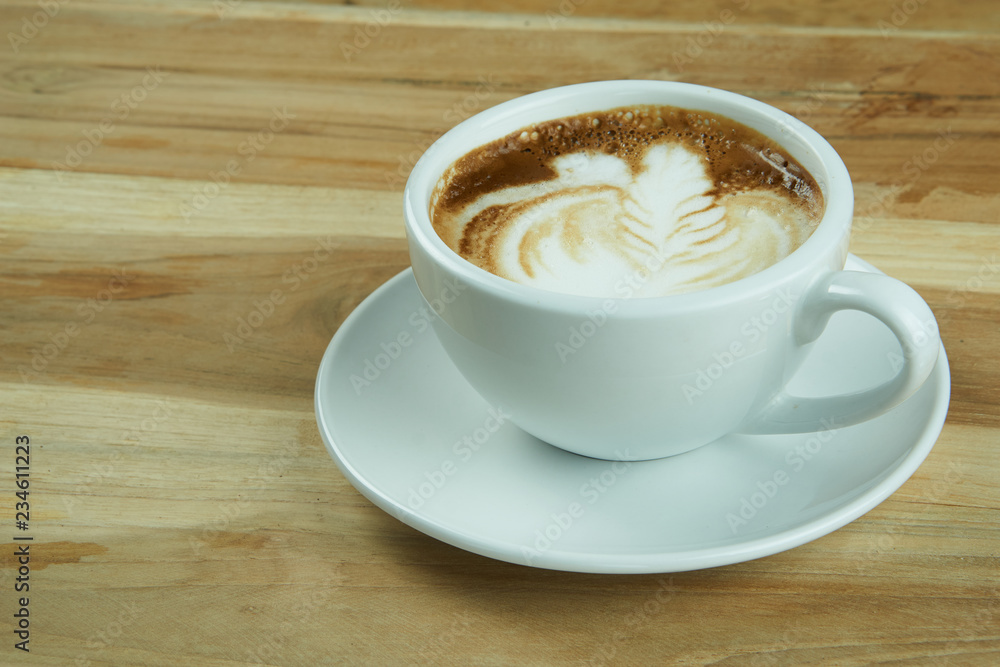 Cappuccino and latte art on the wood table. Free hand pouring some milk on the coffee. Morning breakfast with coffee. Cappuccino and latte art on the wood table. Free hand pouring some milk on the coffee. Morning breakfast with coffee.