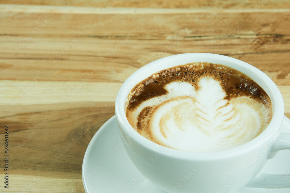 Cappuccino and latte art on the wood table. Free hand pouring some milk on the coffee. Morning breakfast with coffee. Cappuccino and latte art on the wood table. Free hand pouring some milk on the coffee. Morning breakfast with coffee.