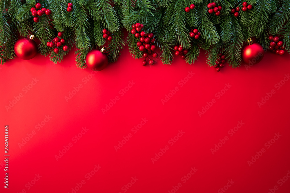 Christmas background concept. Top view of Christmas gift box red sock with spruce branches, pine cones, red berries and bell on red background.