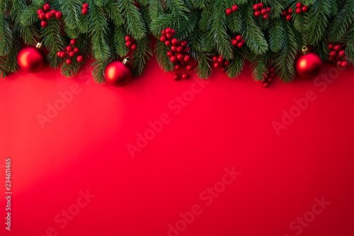 Christmas background concept. Top view of Christmas gift box red sock with spruce branches, pine cones, red berries and bell on red background.