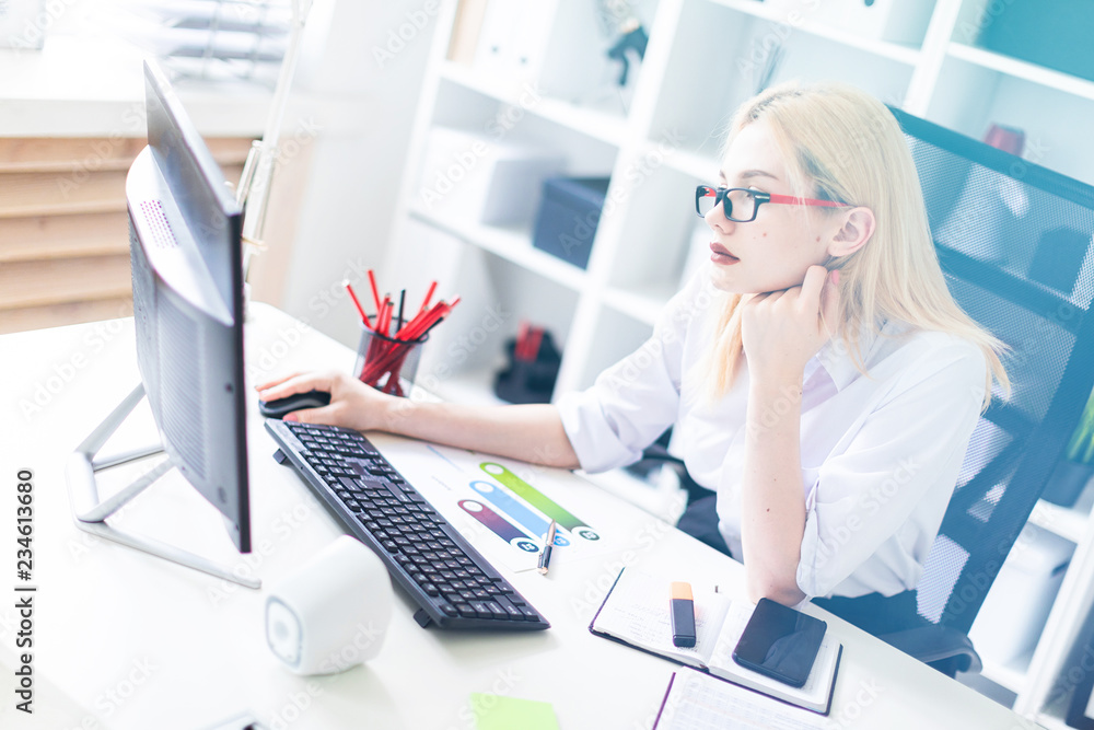 A young girl working at a computer in the office. A young girl working at a computer in the office.